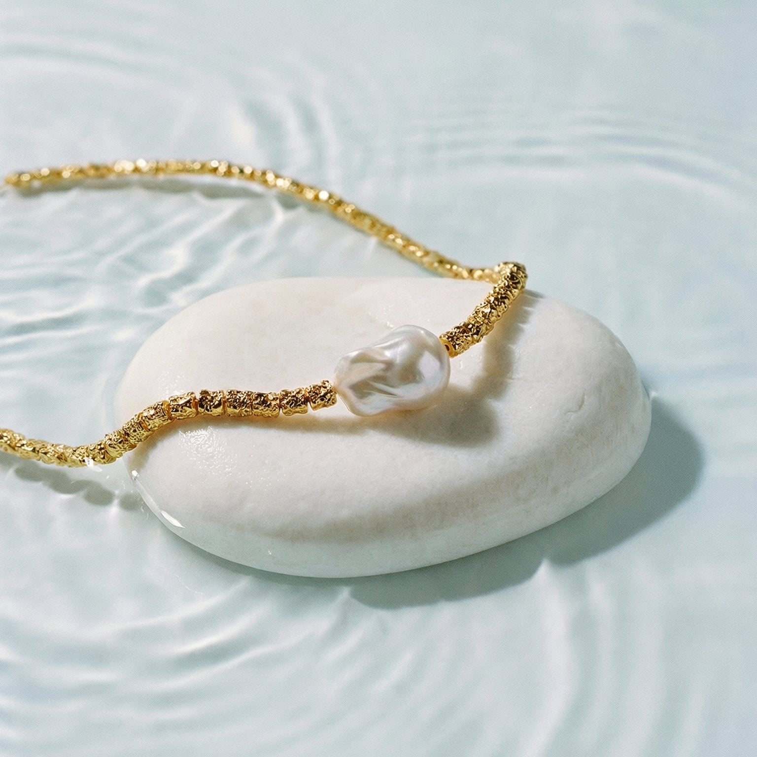 Helena George. Gold bracelet with a pearl on a white stone